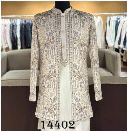 A cream-colored sherwani jacket with intricate gold and silver embroidery, displayed on a black mannequin torso in a clothing store setting.
