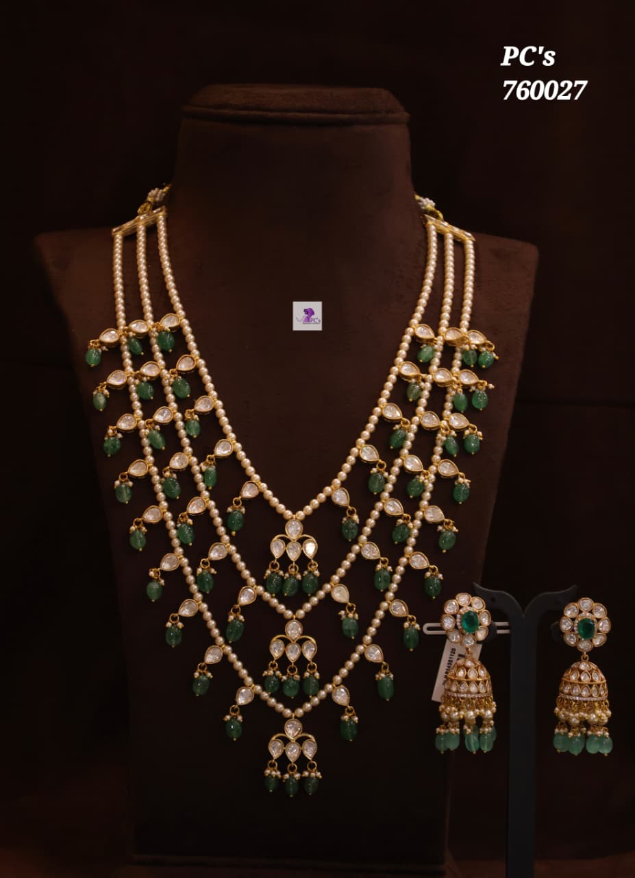 A gold-plated traditional Indian jewelry set featuring a multi-strand pearl necklace with green stone accents and matching drop earrings.