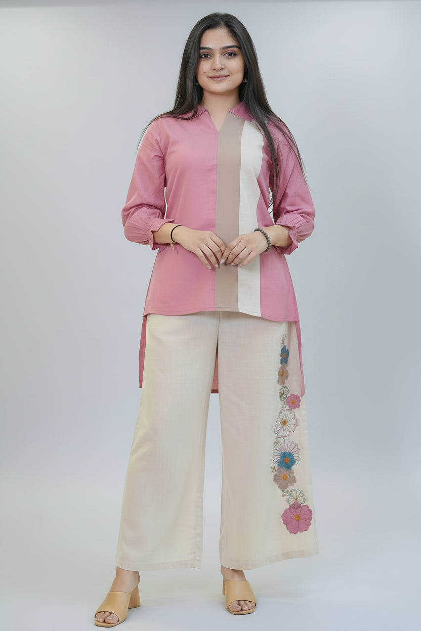 Woman in a pink top and white pants with floral designs standing in front of fabric shelves.