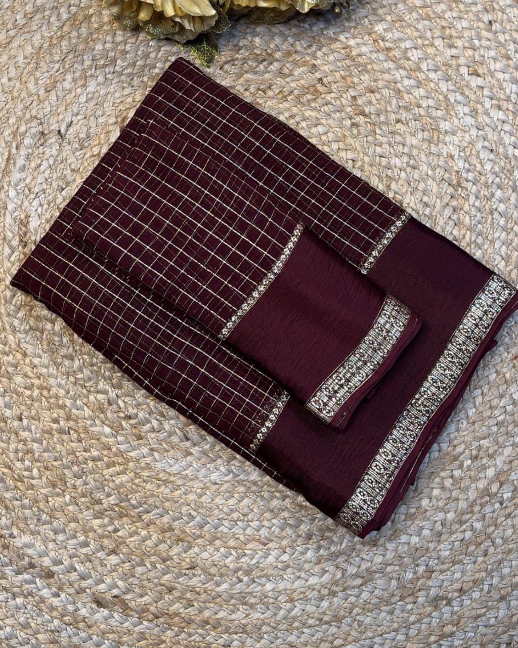 Set of maroon towels with silver trim on a textured beige surface
