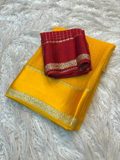Yellow saree with red border on a textured white surface