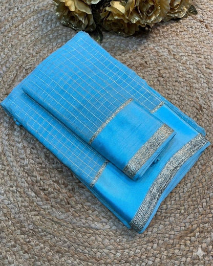 Blue fabric with silver border on a textured surface