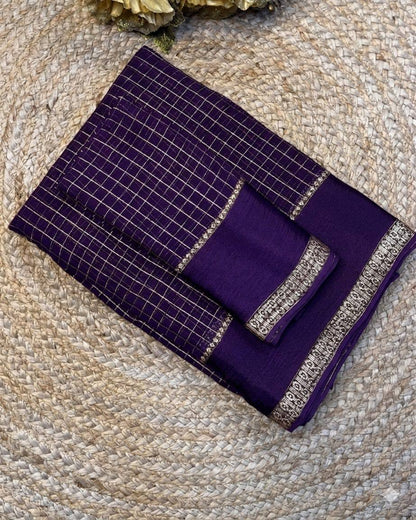 Purple fabric with silver embroidery on a textured surface