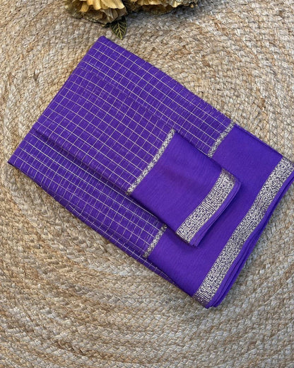 Purple fabric with silver border on a textured surface