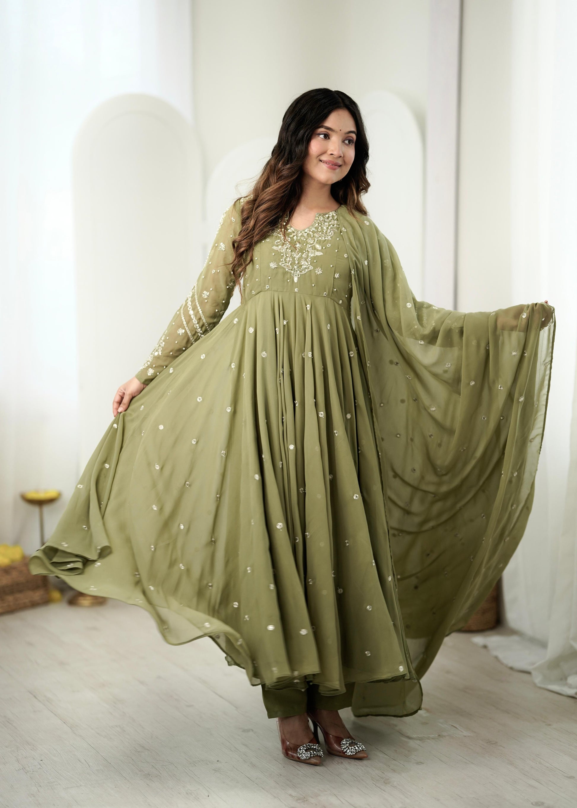 Model in mehendi green embroidered Anarkali gown with dupatta draped open
