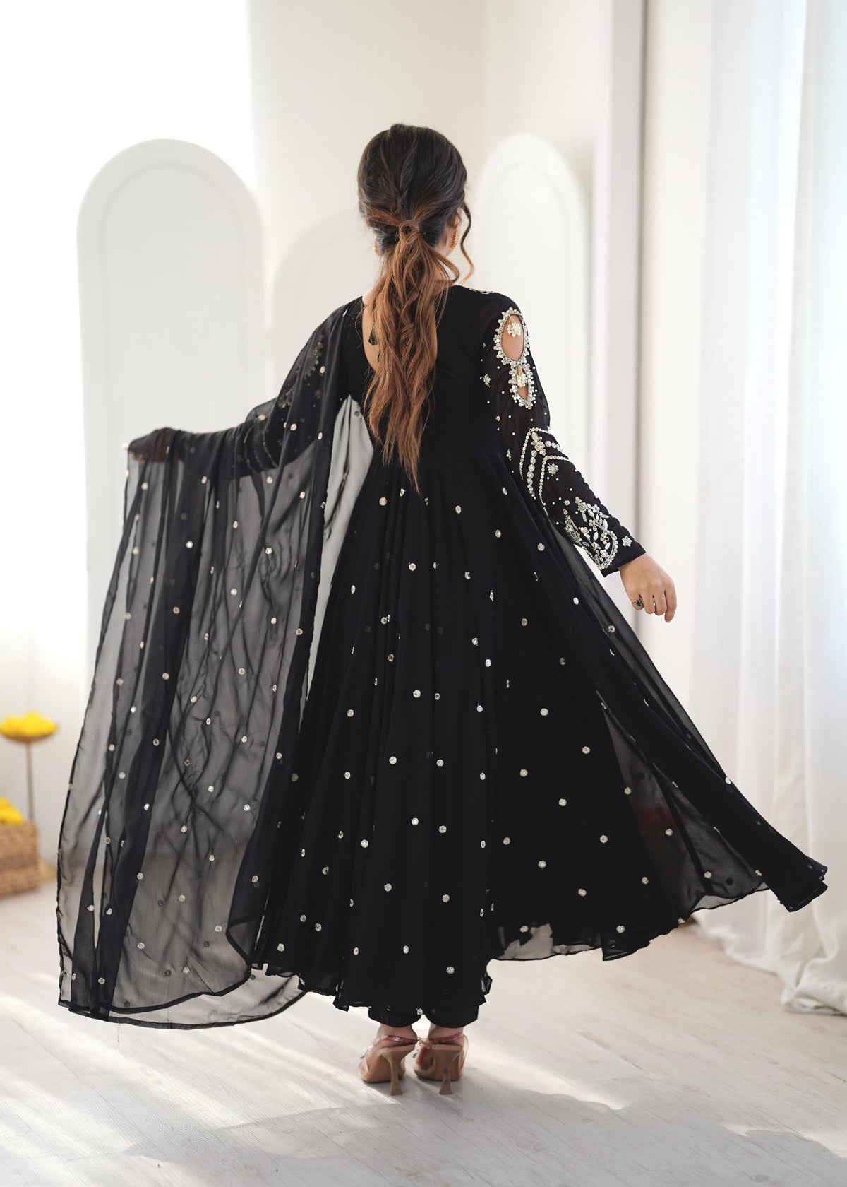 Back view of black Anarkali gown showing keyhole tie-back and embroidered sleeves