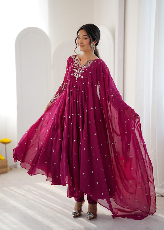 Model twirling in a magenta sequin embroidered Anarkali gown with dupatta