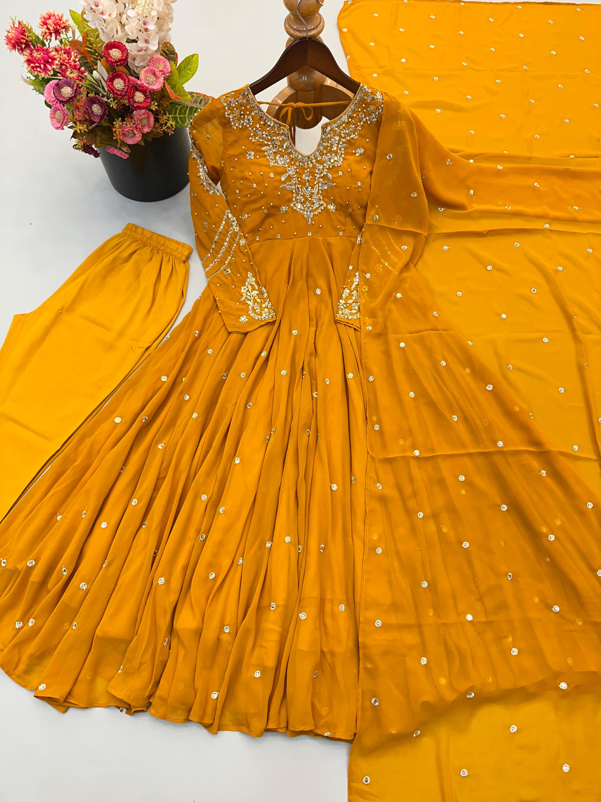 Mustard yellow sequin embroidered Anarkali gown, pants and dupatta set laid flat