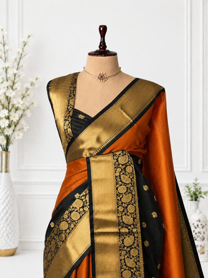 An orange and black silk saree with intricate gold zari brocade work, displayed on a mannequin torso with a matching black blouse.