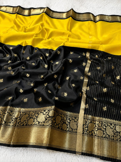 A black and yellow Banarasi silk saree with intricate gold zari embroidery, displayed flat on a white textured background.