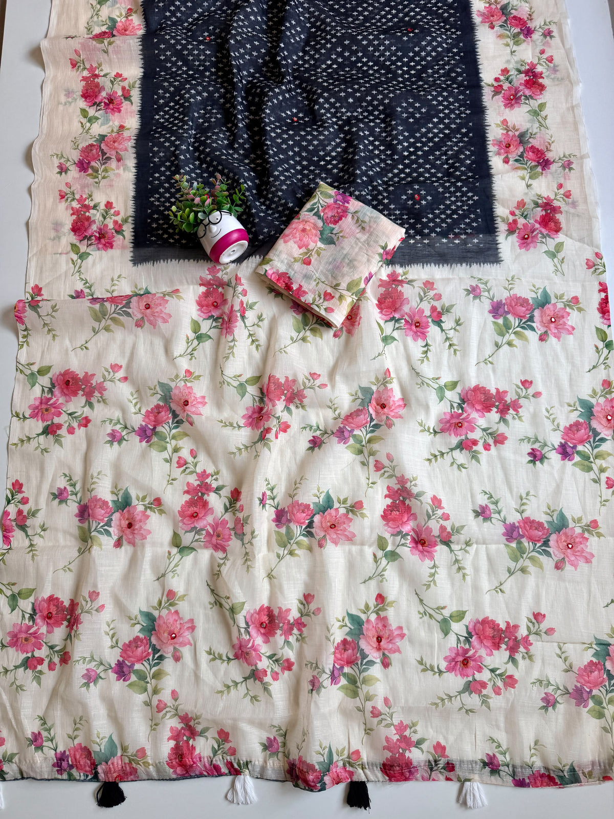 Dark navy cotton linen saree full spread with cream floral print pallu, mirror accents and black and white tassels