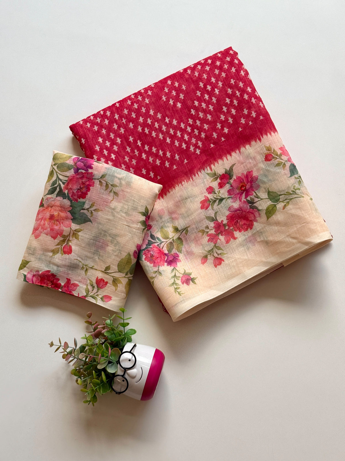 Red linen cotton saree with white cross-motif print and floral digital print border, folded with printed blouse piece