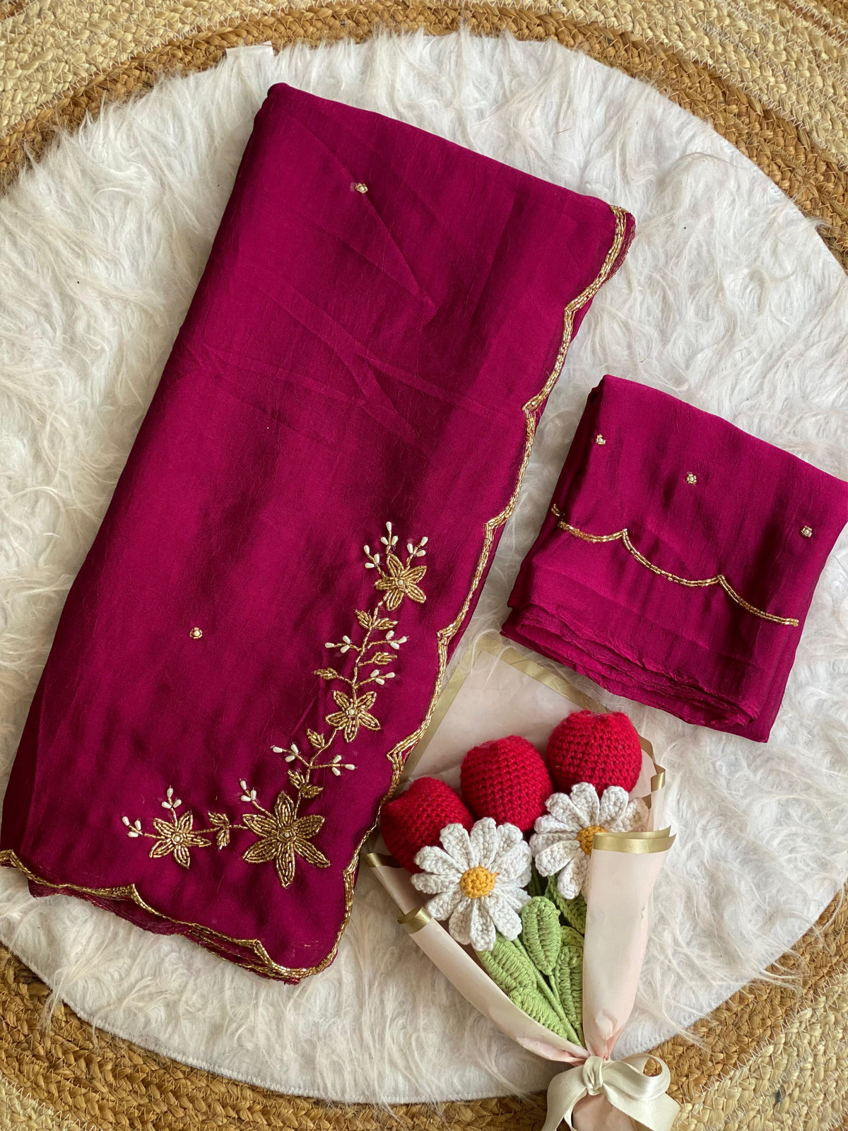 Magenta crush silk saree folded with blouse piece, gold bead and pearl floral handwork on the pallu and scalloped bead border