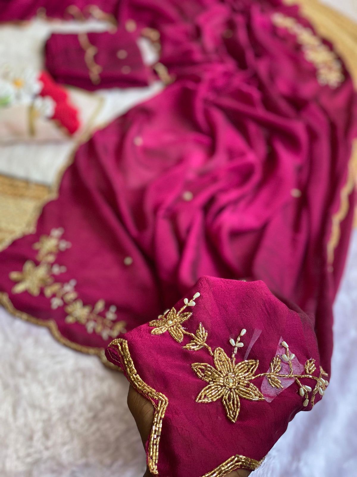 Close-up of gold tube bead and pearl drop floral handwork on Magenta crush silk saree with scalloped bead edge