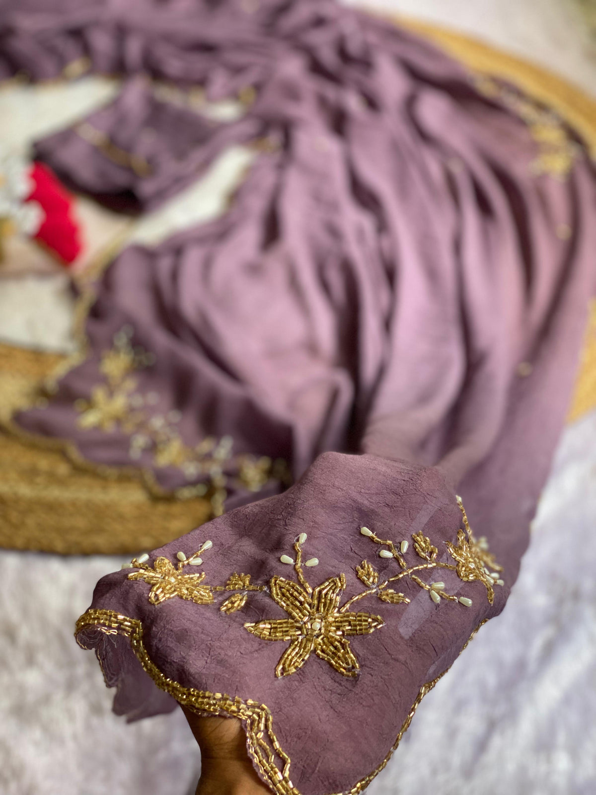 Close-up of gold tube bead and pearl drop floral handwork on Mauve crush silk saree with scalloped bead edge