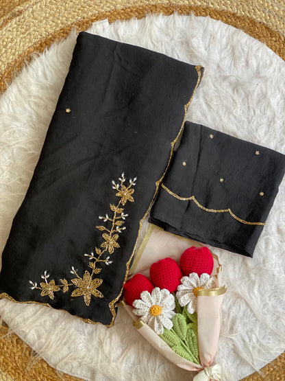 Black crush silk saree folded with blouse piece, gold bead and pearl floral handwork on the pallu and scalloped bead border
