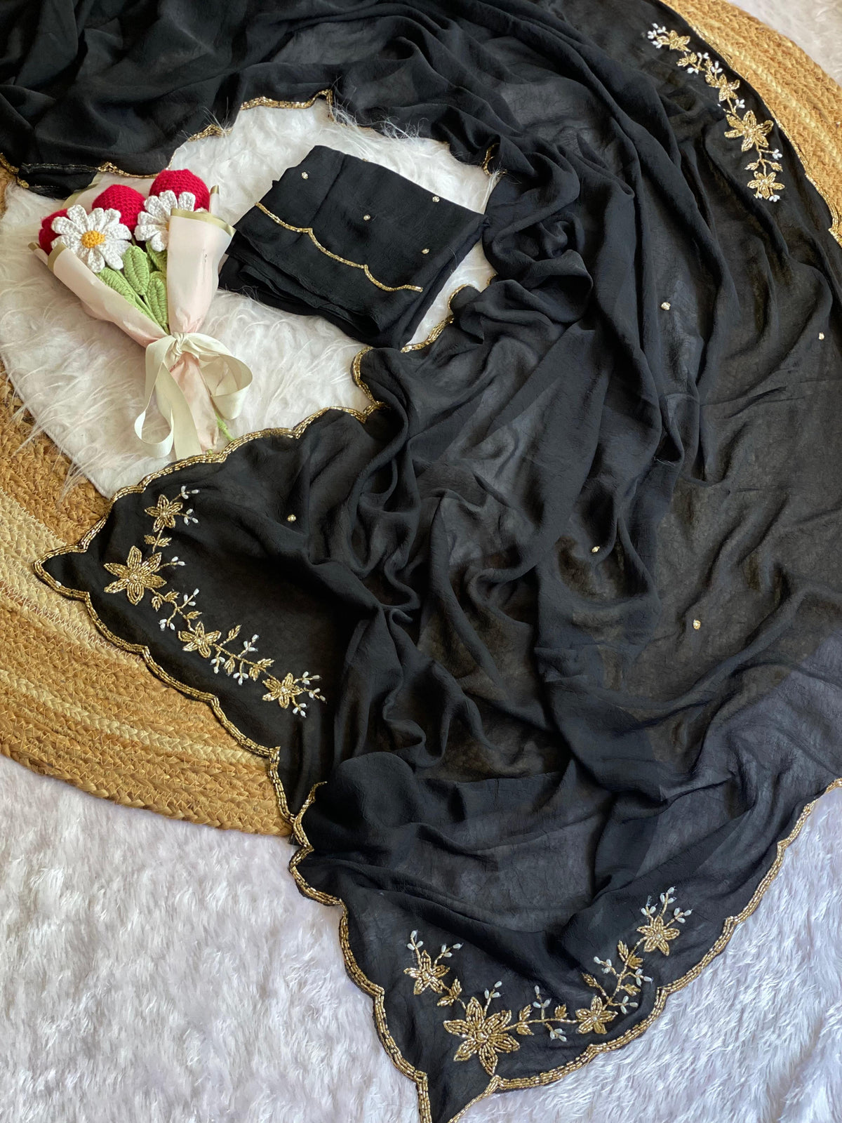 Black crush silk saree spread out showing butta pallu, scattered bead buttis and scalloped gold bead border