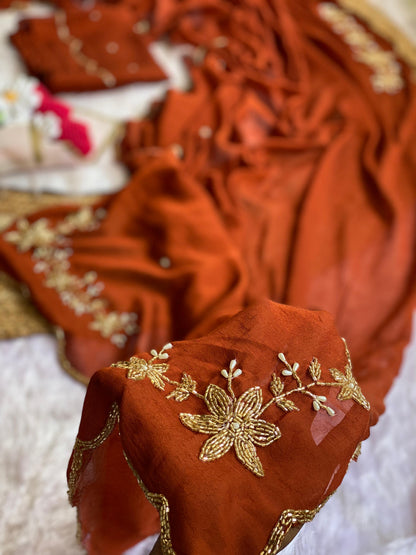 Close-up of gold tube bead and pearl drop floral handwork on Rust crush silk saree with scalloped bead edge