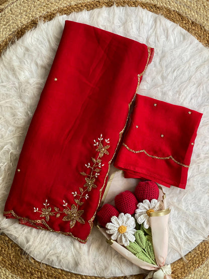 Red crush silk saree folded with blouse piece, gold bead and pearl floral handwork on the pallu and scalloped bead border