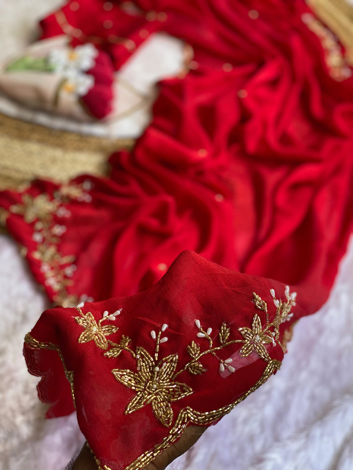 Close-up of gold tube bead and pearl drop floral handwork on Red crush silk saree with scalloped bead edge