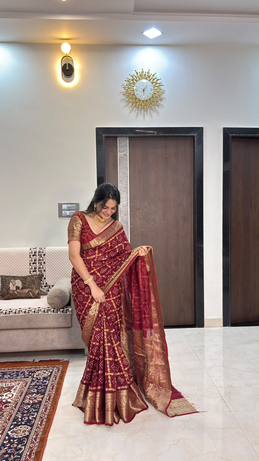 Maroon bandhani saree showing zari border and pallu spread