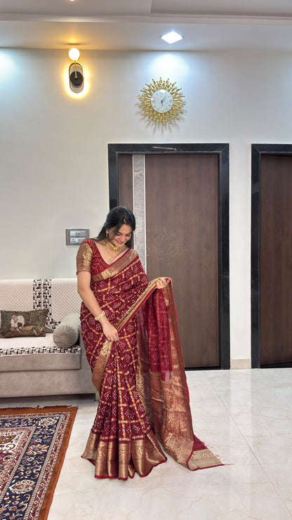 Maroon bandhani saree showing zari border and pallu spread