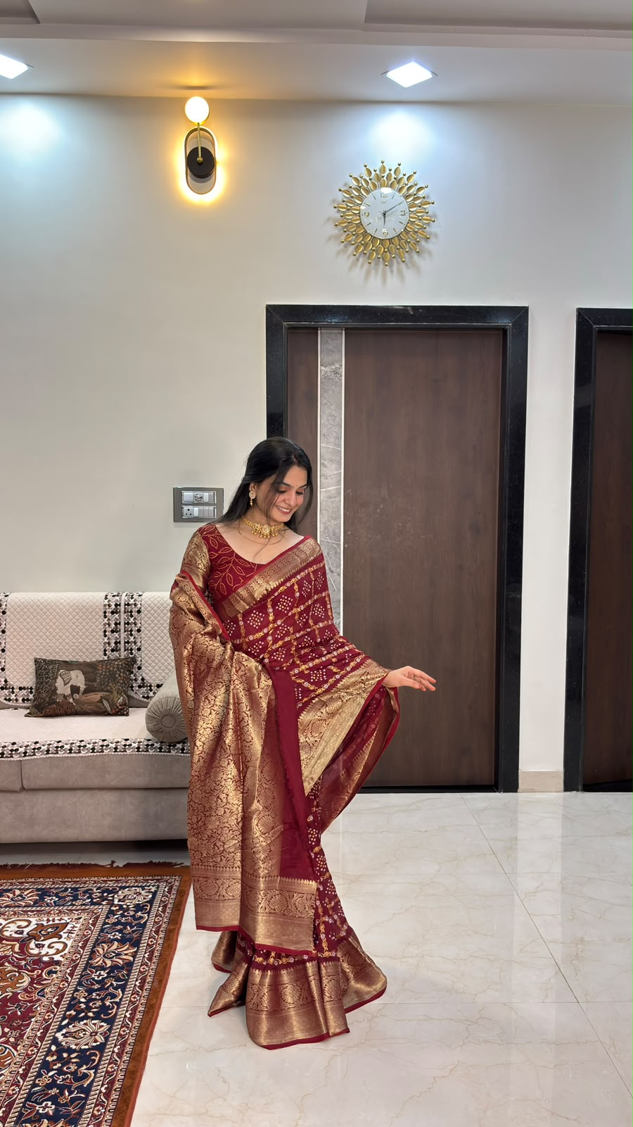 Maroon bandhani cotton silk saree with heavy zari pallu draped over the arm