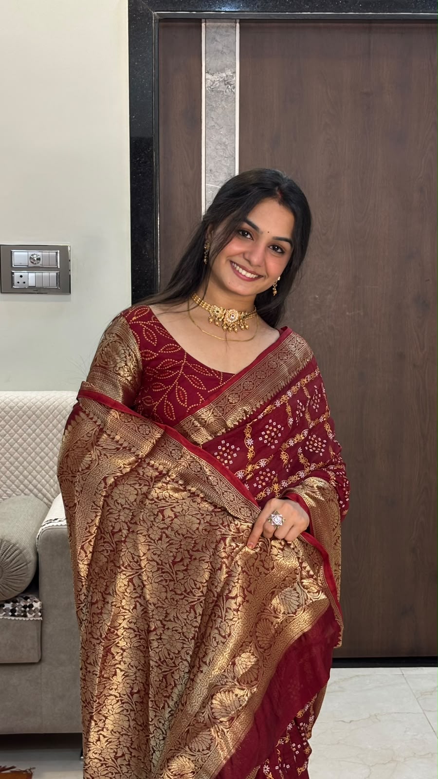 Close-up of rich gold zari pallu on maroon bandhani saree