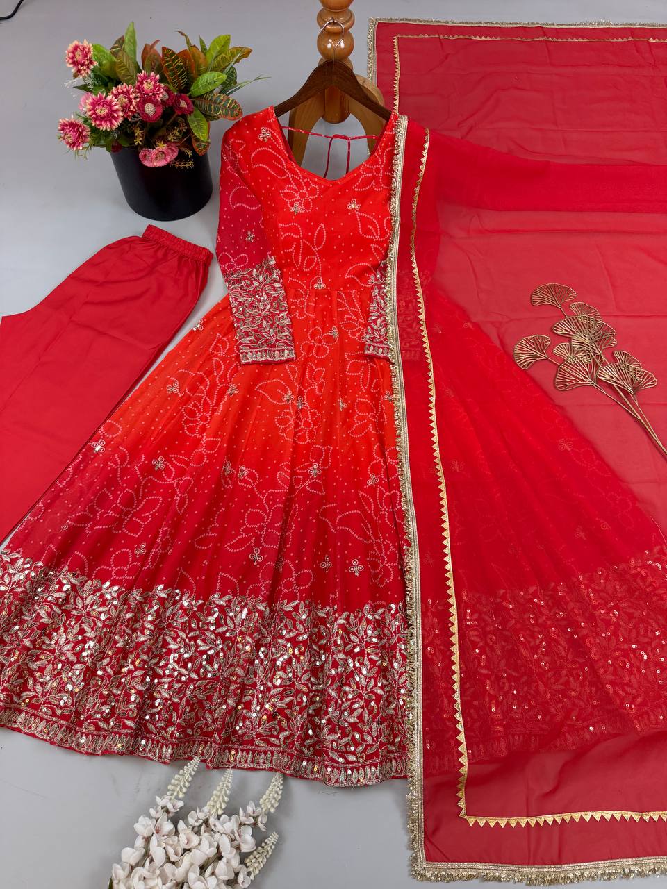 Bandhani print Anarkali set flat-lay with red pant and lace border faux georgette dupatta