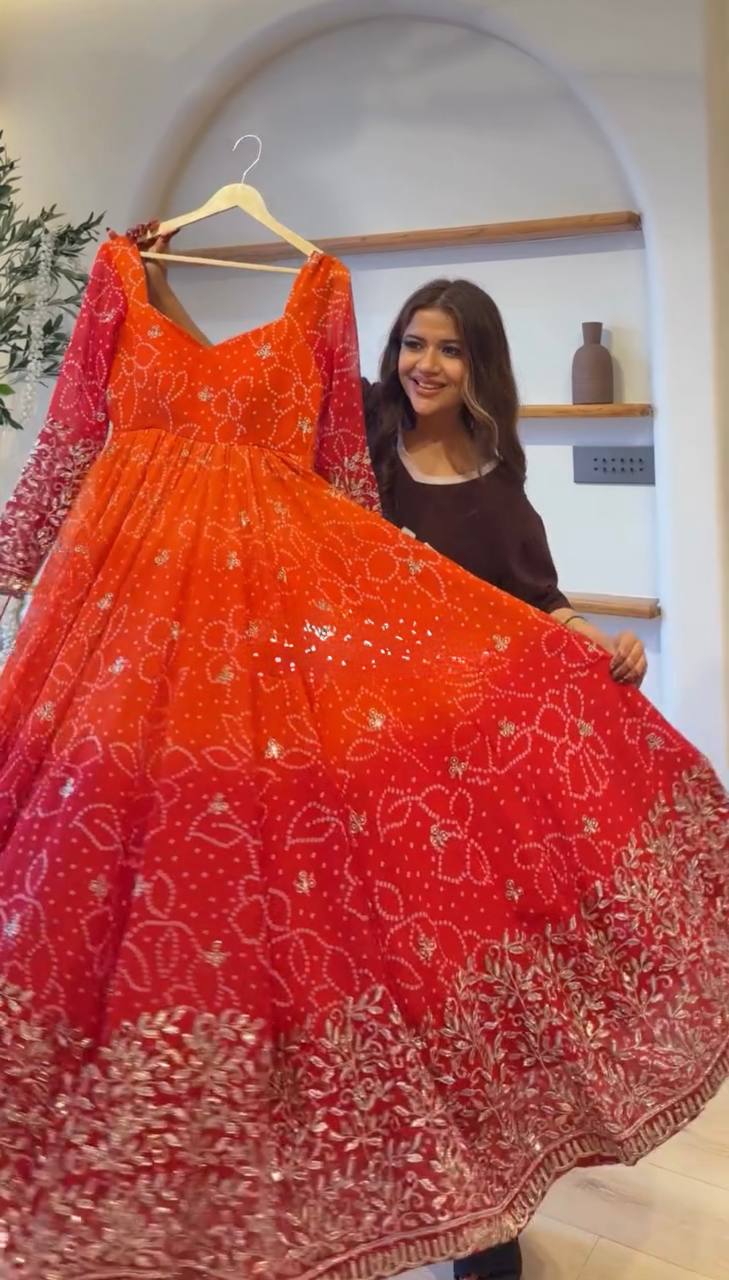 Flared orange to red Anarkali on a hanger showing sequin embroidered hem border