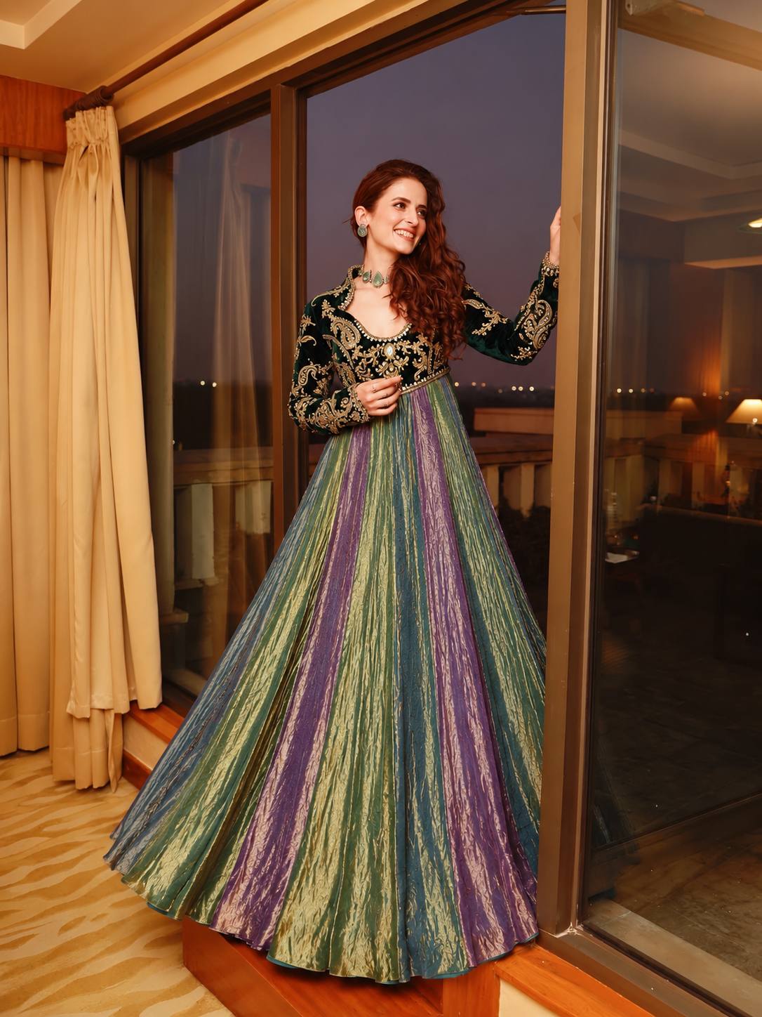 Model in multicolour Anarkali gown with bottle green embroidered velvet bodice and full sleeves
