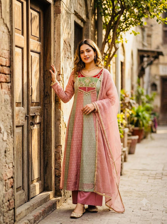 Model in pink and mint green panelled Anarkali gown with red sequin embroidered yoke and pink lace dupatta