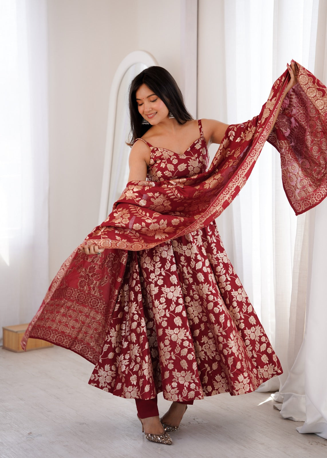 Model swirling maroon jacquard dupatta over a sweetheart neck Anarkali gown with matching pant