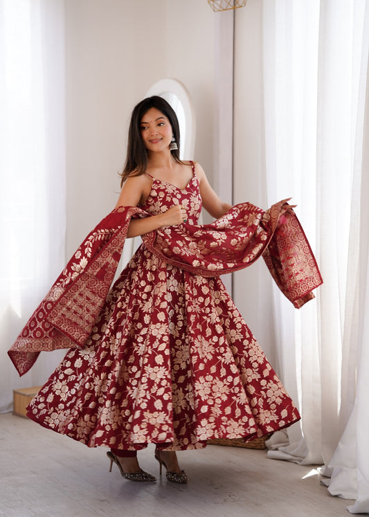 Maroon sleeveless Anarkali gown with flared skirt and woven border dupatta draped across both arms