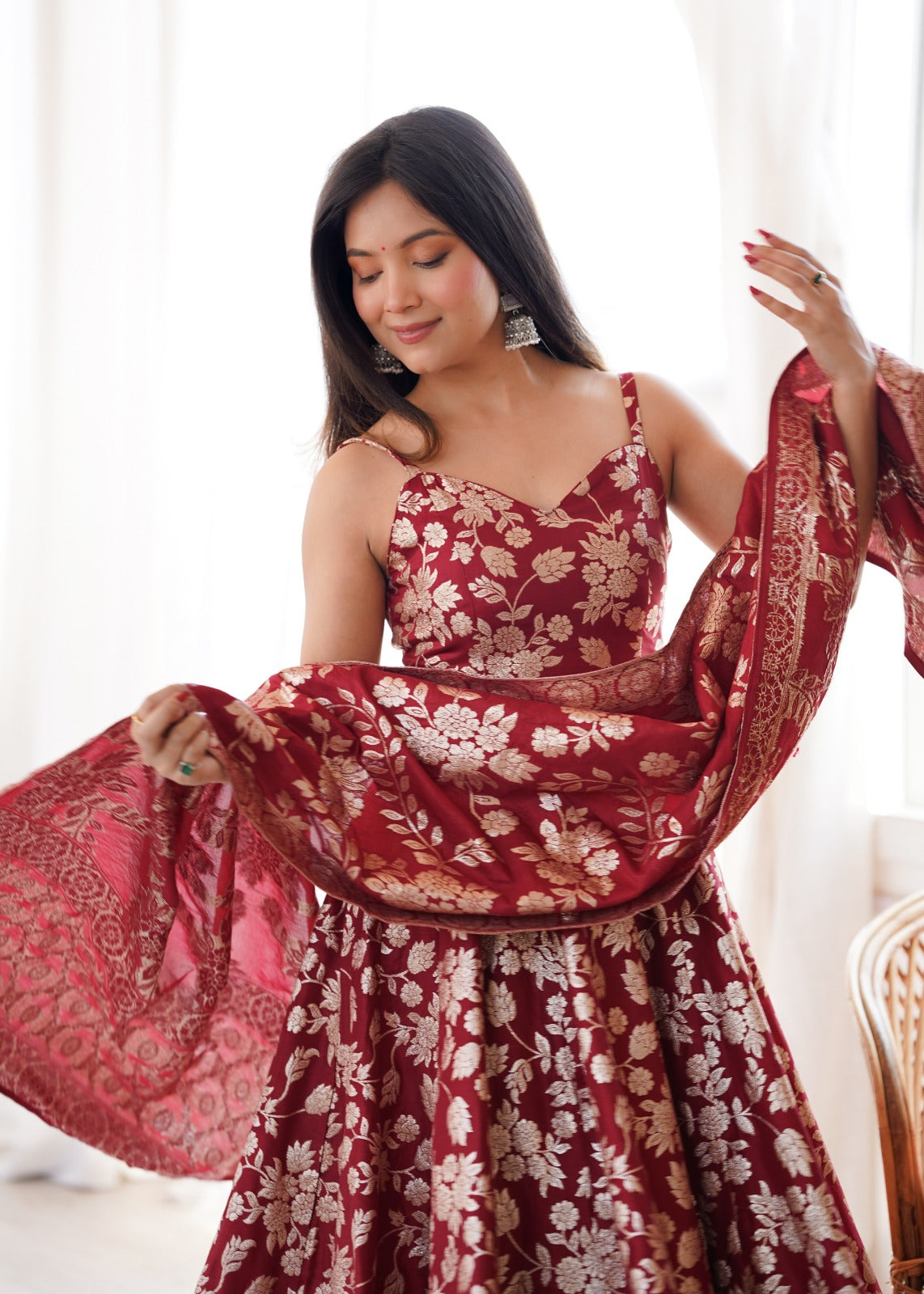 Close-up of maroon sweetheart bodice with strap and gold-toned woven floral motifs
