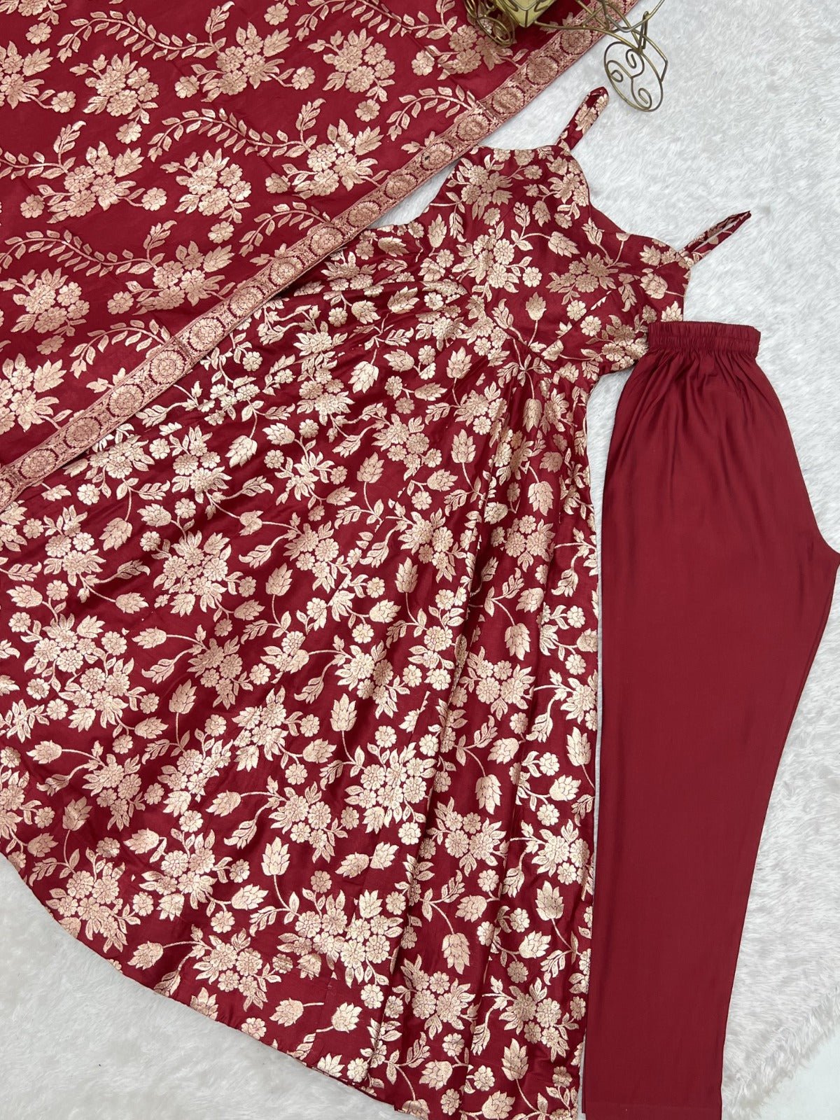Maroon jacquard Anarkali gown flat-lay with plain maroon pant and woven border dupatta