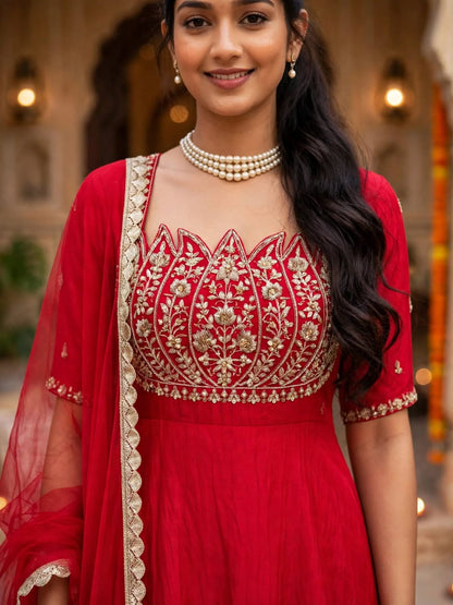 Close-up of model wearing red lotus yoke Anarkali gown with pearl choker and net dupatta