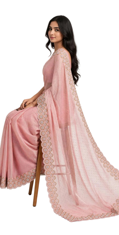 Seated side view of the pink stone work saree with the pallu flowing to the floor