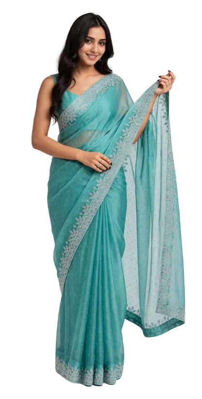 Model wearing a teal space silk saree with silver stone work, front view holding the sheer pallu with its leaf vine stone border