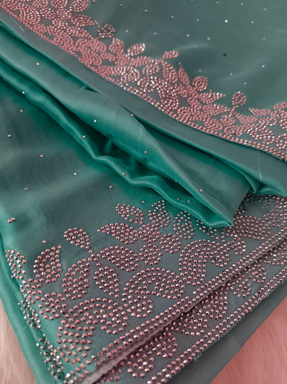 Close-up of the folded saree showing the leaf vine silver stone border and scattered stones